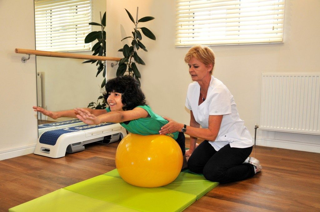 A young patient doing a supported strengthening exercise in the clinic studio